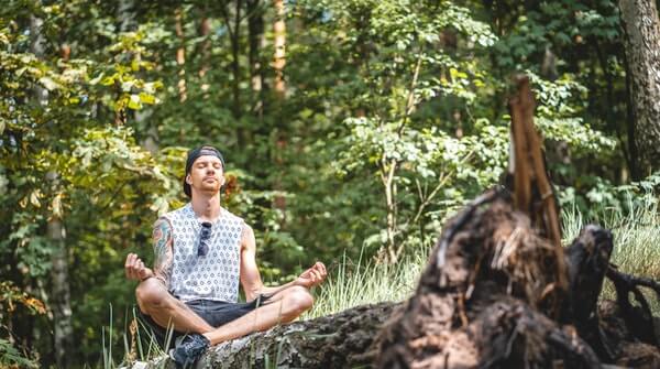 a man doing meditation outdoors to experience the nature with mindfulness