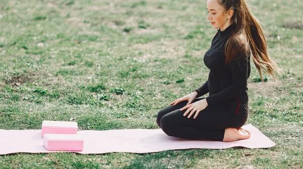 A woman setting up her space for yoga practice