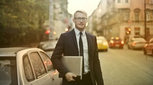 A man is wearing a formal suit to complete the interview dress code. He is looking all-ready to give an interview.