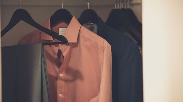 Perfect formal shirts and a trouser to make a complete formal dress code for interview. They are hanging in a closet.